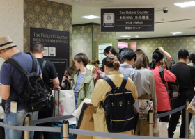 百貨店の免税カウンターに並ぶ訪日外国人旅行者ら＝２０１８年４月、大阪市中央区