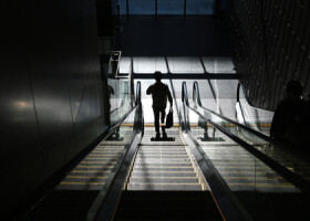 オフィスビルのエスカレーターに乗る男性（ＡＦＰ時事）