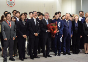花束を手に、日本オリンピック委員会職員らとの写真撮影に臨む国際オリンピック委員会のバッハ会長（前列中央）＝９日午後、東京都新宿区